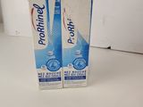 two boxes of toothpaste sitting on top of a white counter