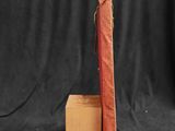 an old red book sitting on top of a wooden block