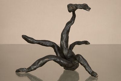 une sculpture en bronze représentant un homme tombant d'un arbre