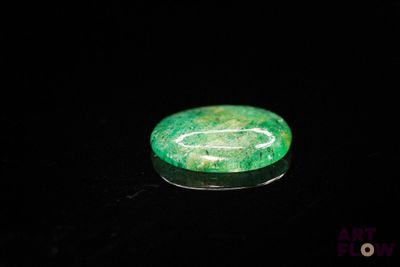 a close up of a green stone on a black surface
