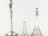 three silver candlesticks sitting next to each other on a table