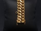 a gold bracelet on a black pillow