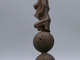 a close up of a sculpture of a person sitting on top of three balls