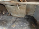 a dirty floor in a dirty car with a dirty seat