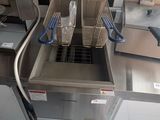 a picture of a commercial kitchen with two deep fryers