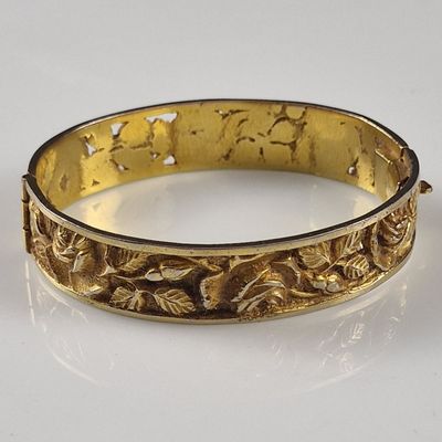 an image of a gold bracelet on a white surface