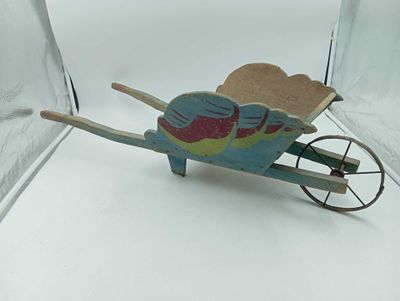 a small wooden toy wheelbarrow with a bird on it