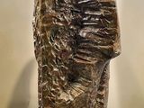 sculpture of a man ' s head on a pedestal in a museum