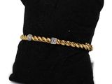 a gold and diamond bracelet on a black pillow