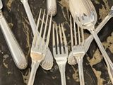 beaucoup de fourchettes et de cuillères en argent sur une table