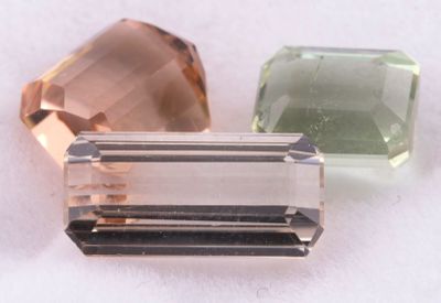 trois pierres de couleurs différentes posées les unes à côté des autres sur une surface blanche
