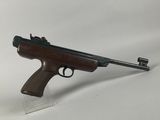 a rifle with a wooden barrel on a clear plastic stand