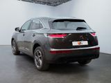 the rear end of a grey car in a white room
