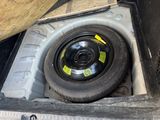 a tire in the trunk of a truck with a tire on it