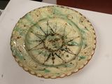 une assiette blanche ornée d'un motif vert et marron