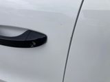 a close up of a car door handle on a white car
