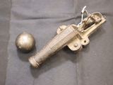 un pistolet jouet et une balle posés sur un tissu noir
