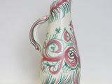 a white and pink vase with a green design on it