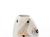 un vase blanc orné d'un motif noir et orange