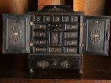 une petite armoire noire dont la porte est ouverte, posée sur une table