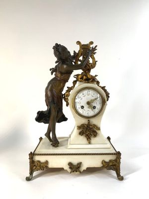 a statue of a woman holding a clock on a table