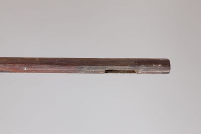 a close up of a gun with a wooden barrel on a white background