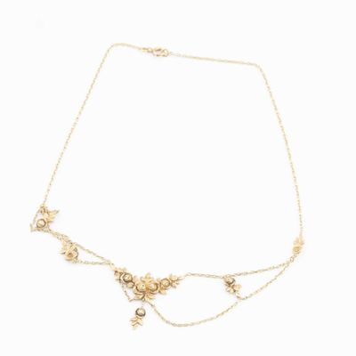 a gold necklace with pearls and a cross on a chain
