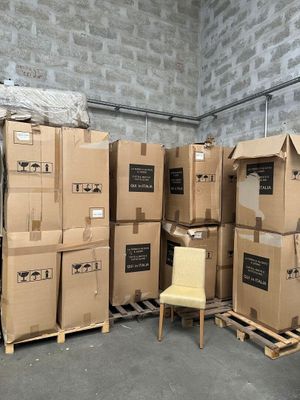 de nombreux cartons et une chaise dans une pièce aux murs en briques