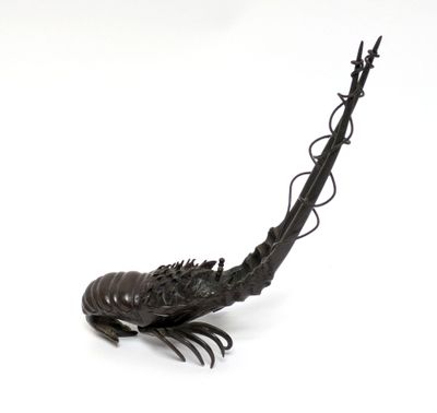 a metal sculpture of a fish on a white surface