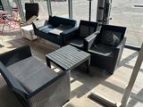 un canapé, un fauteuil, une table et une télévision dans une pièce