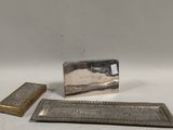 deux pièces métalliques argentées sont posées sur une surface blanche