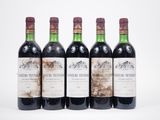 quatre bouteilles de vin sont alignées sur une surface blanche