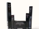 three black boxes of chanel cosmetics on a white background