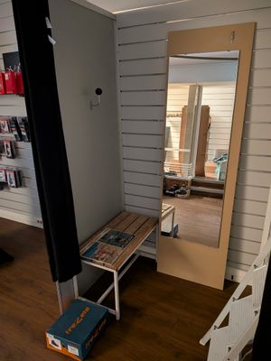 a room with a mirror, a bench, and a book shelf