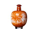 un vase orange orné d'une fleur blanche