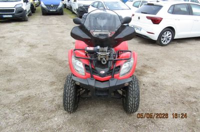 une photo d'un quad rouge garé sur un parking