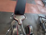a black and red bench in a gym with a red wall behind it