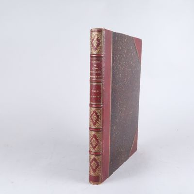 un vieux livre à la couverture rouge posé sur une surface blanche