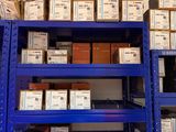 Les cartons sont empilés sur des rayonnages dans un entrepôt, avec d'autres cartons posés dessus