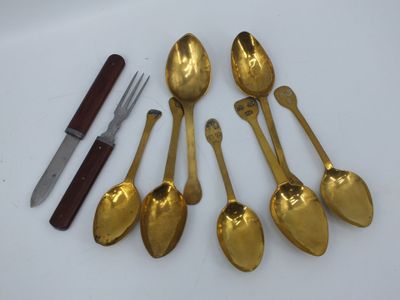 cinq cuillères, un couteau et un repose-couteau posés sur une table
