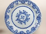 une assiette bleue et blanche ornée d'un motif floral