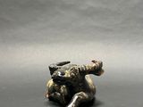 figurine of a dog laying on its back on a gray surface
