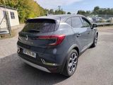 the rear end of a grey car parked in a parking lot
