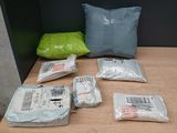 many bags of items on a table with a pillow