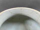 underside view of a white porcelain vase with a rusted rim