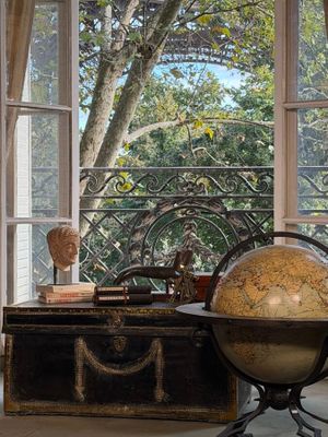 a large globe sitting on a table in front of a window
