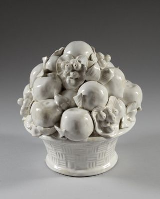 un vase blanc contenant un bouquet de fruits
