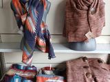 several scarves and scarves are displayed on a shelf in a store