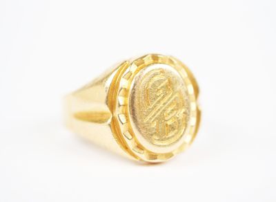 a close up of a gold ring with a gold seal on it