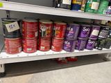 many cans of paint on a shelf in a store